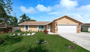 a house with a garage in a yard at Beautiful Home Away From Home in Royal Palm Beach