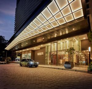 ein Auto, das vor einem Gebäude mit Lichtern parkt in der Unterkunft Societe Suite by Lyfehaus in Kuala Lumpur