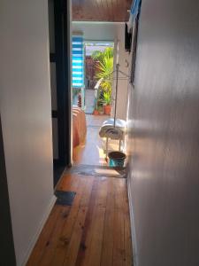 einen Flur mit Holzboden und einer offenen Tür in der Unterkunft Hostal La Casa del Puente in Santiago