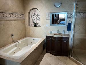 baño grande con bañera y lavamanos en Oceanview Condo Resort. Las Olas Grand Rosarito, en Divisadero