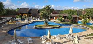 a large swimming pool with chairs and umbrellas at Gravatá sonho de estadia - 928 in Gravatá