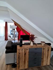 a living room with a couch and a desk under a stairs at Wohnen über den Dächern von Bregenz in Bregenz