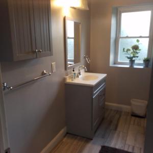 a bathroom with a sink and a mirror and a window at Fairmount House in Philadelphia