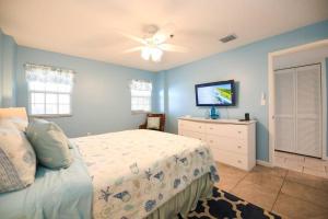 a bedroom with a bed and a flat screen tv at Welcome to the Pelican Lodge ! in Tavernier