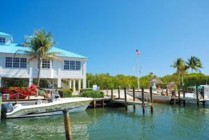 um barco ancorado numa doca em frente a uma casa em Welcome to the Pelican Lodge ! em Tavernier