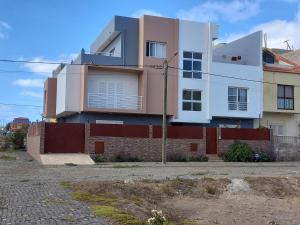 una casa blanca con una valla roja delante de ella en Nifa House, en Espargos