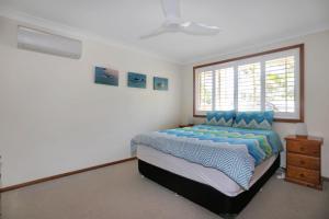 a bedroom with a bed and a window at Jimmys Beach Escape in Hawks Nest