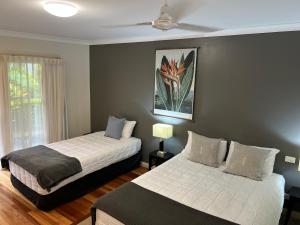 a bedroom with two beds and a ceiling fan at The Arabella North Coast in Wollongbar