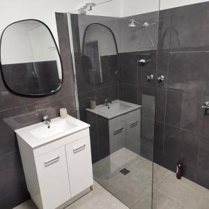 a bathroom with two sinks and a shower with a mirror at City Villa 41 Blende st Broken Hill NSW 2880 in Broken Hill
