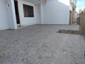 a room with a stone floor and a white wall at Casa España in Sincelejo