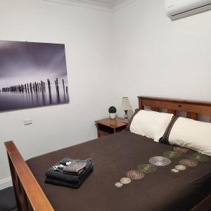 Un dormitorio con una cama con una mesa con monedas. en City Villa 41 Blende st Broken Hill NSW 2880 en Broken Hill