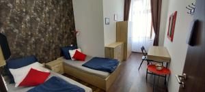 een kamer met 2 bedden met blauwe en rode kussens bij Klauzal 14 in Boedapest