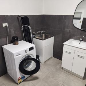 布罗肯希尔City Villa 41 Blende st Broken Hill NSW 2880的配有洗衣机和水槽的浴室