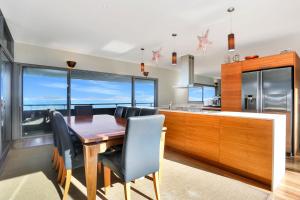 a kitchen with a wooden table and black chairs at Architectural Design on the Beach in Winda Woppa