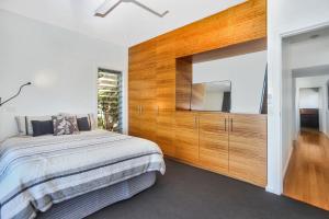 ein Schlafzimmer mit einem Bett und einem großen Holzschrank in der Unterkunft Architectural Design on the Beach in Winda Woppa