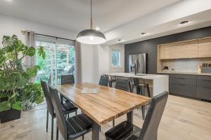 uma cozinha e sala de jantar com uma mesa de madeira e cadeiras em FREE PARKING PRIME LOCATION NEW MODERN CONDO em Brossard