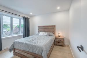 a bedroom with a large bed and a window at FREE PARKING PRIME LOCATION NEW MODERN CONDO in Brossard