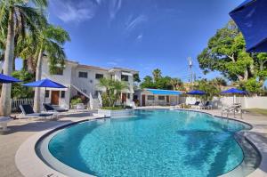 una piscina con sombrillas azules y una casa en Gulfside Resort. Unit 3, en St Pete Beach