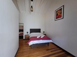 1 dormitorio con 1 cama con 2 toallas en Marina's House Cusco Centro, en Cusco