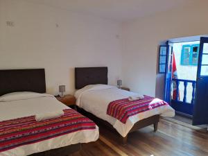 1 dormitorio con 2 camas y ventana en Marina's House Cusco Centro, en Cusco