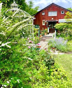 a garden in front of a red barn at Gallery HARA and guest house in Hara
