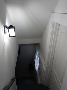 a stairway with a light next to a white door at Cozy Basement Apartment, 40-Min Drive to NY City in Irvington