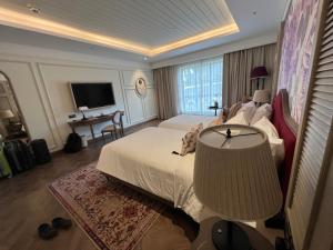 a hotel room with a bed and a television at Nancy Grand Villa seaview 2 in Vung Tau