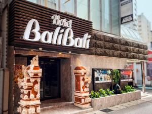 un ristorante con un cartello sul lato di un edificio di Hotel BaliBali Matsudo a Matsudo