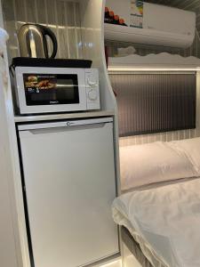a refrigerator with a microwave on top of it at كرفان الياسمين in Al Hada