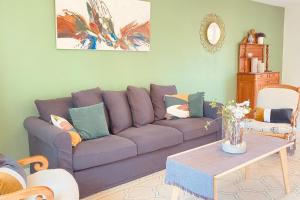 ein Wohnzimmer mit einem lila Sofa und einem Tisch in der Unterkunft Cozy house with garden in La Teste-de-Buch in La Teste-de-Buch