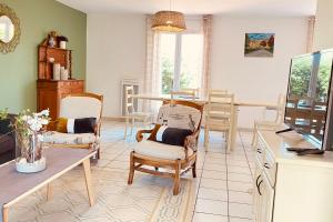 ein Wohnzimmer mit 2 Stühlen und einem Tisch in der Unterkunft Cozy house with garden in La Teste-de-Buch in La Teste-de-Buch