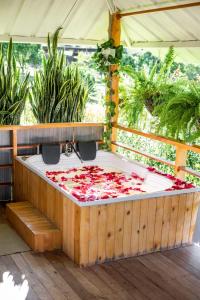 bañera de hidromasaje con pétalos de rosa roja en la cubierta en Finca Saabu en Isnos