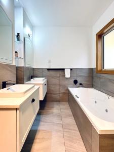 baño con bañera grande y lavamanos en The Shan's Lodge en Queenstown