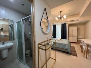 ダバオシティにあるINSPIRIA TOWER CONDOMINIUM 1211のベッドと洗面台と鏡のあるバスルーム
