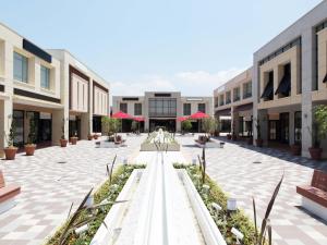 an empty courtyard of a building with red umbrellas at Hotel Royal Garden Kisarazu / Vacation STAY 72210 in Kisarazu