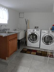 een keuken met een wasmachine en een wastafel bij Cozy Basement Apartment, 40-Min Drive to NY City in Irvington