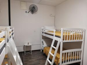 une chambre avec trois lits superposés et un ventilateur dans l'établissement G FORTUNE GUEST HOUSE+, à George Town