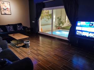 a living room with a couch and a table and a tv at Valley Villa in Jeddah