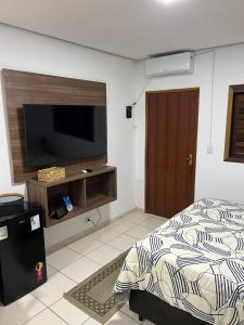 - une chambre avec un lit et une télévision à écran plat dans l'établissement Studio equipado centro, à São Lourenço da Serra