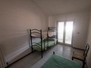 Piccola camera con letto a castello e finestra. di Appartamento Sole a San Benedetto del Tronto