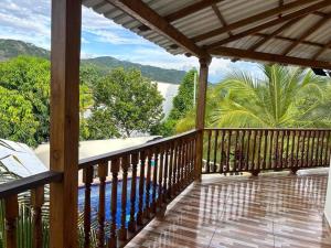 a wooden balcony with a view of the ocean at Villa Jade - Santafe de Antioquia in Santa Fe de Antioquia