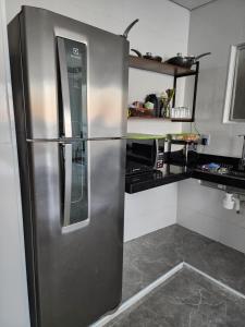 a stainless steel refrigerator in a kitchen at Frente mar in Praia Grande