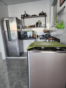 a kitchen with a stove and a refrigerator at Frente mar in Praia Grande