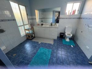 a bathroom with a toilet and a sink at Private self check in home in Alice Springs
