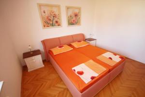ein Schlafzimmer mit einem Bett mit einer orangefarbenen Bettdecke in der Unterkunft Apartment Maris with nice sea view in Ljubač