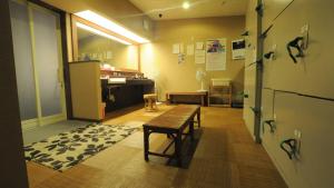 ein leeres Zimmer mit einem Tisch und einem Kühlschrank in der Unterkunft Yourou Onsen Honkan in Onomichi