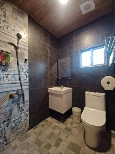 La salle de bains est pourvue de toilettes, d'un lavabo et d'une fenêtre. dans l'établissement 陽光小灣旅店, à Kenting