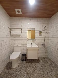 La salle de bains est pourvue de toilettes et d'un lavabo. dans l'établissement 陽光小灣旅店, à Kenting