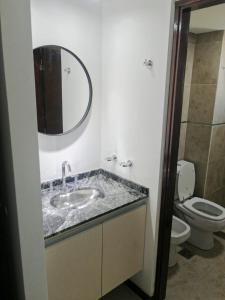 a bathroom with a sink and a toilet and a mirror at Departamento Veneto Village - B in Villa Parque Siquiman