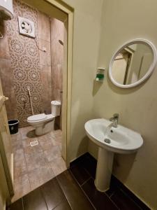 a bathroom with a sink and a toilet and a mirror at Valley Villa in Jeddah